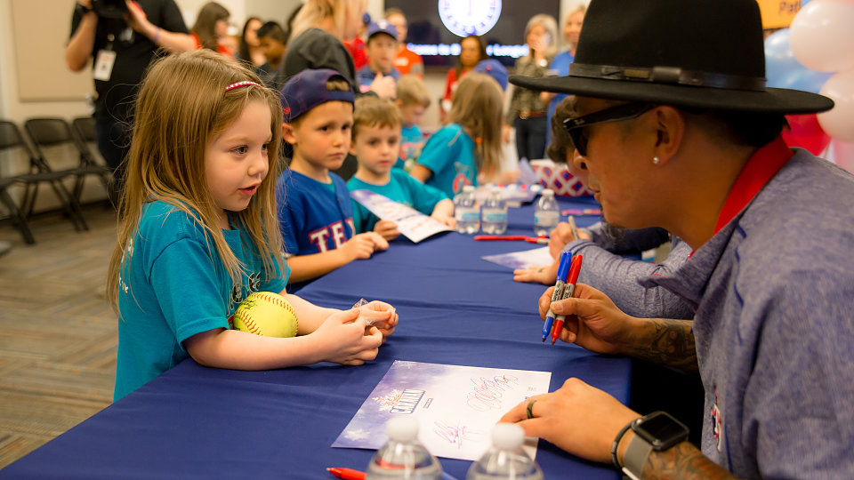 jesse chavez autographs a softball for a young fan
